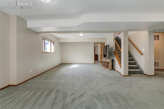 below grade area with baseboards, visible vents, stairway, and carpet