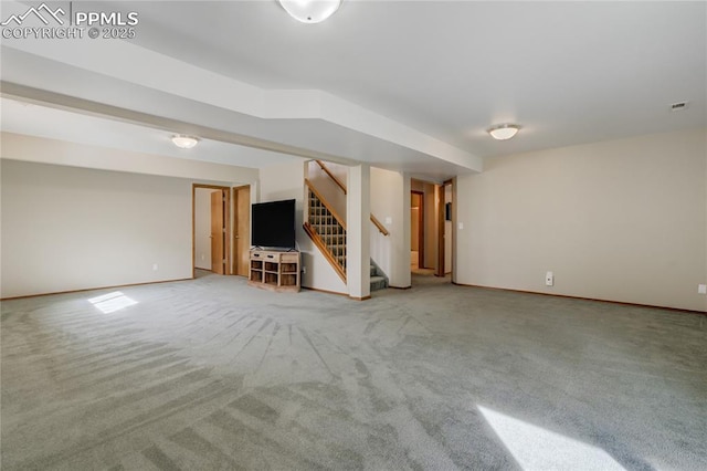 finished basement featuring baseboards, carpet, visible vents, and stairway