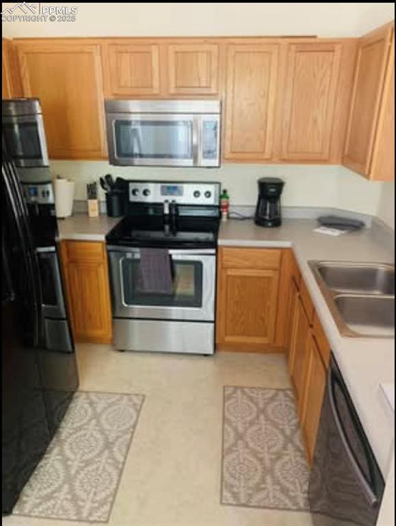 kitchen with black appliances, light countertops, and a sink