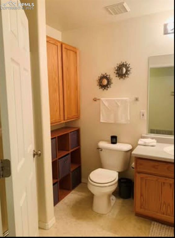 bathroom with visible vents, toilet, and vanity