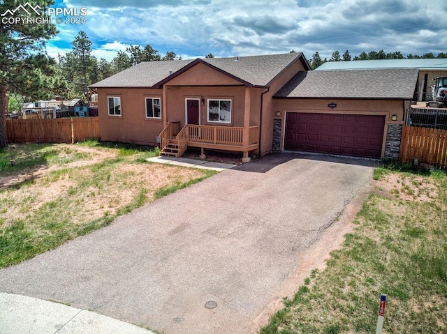 ranch-style home featuring stucco siding, an attached garage, and fence