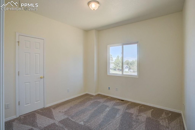 carpeted spare room with baseboards