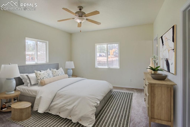 bedroom with baseboards, multiple windows, ceiling fan, and carpet flooring