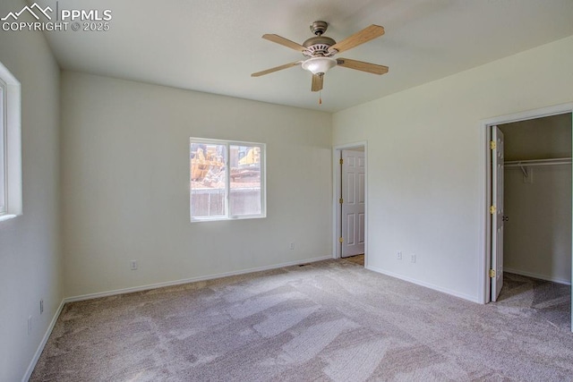 unfurnished bedroom with baseboards, carpet floors, and a spacious closet