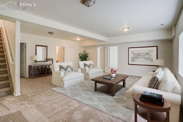 carpeted living area featuring stairs