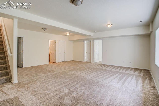 spare room with light carpet, visible vents, stairs, and baseboards