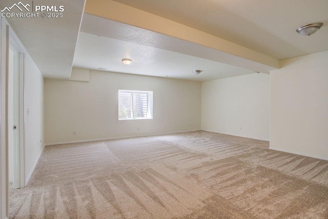 carpeted spare room featuring baseboards