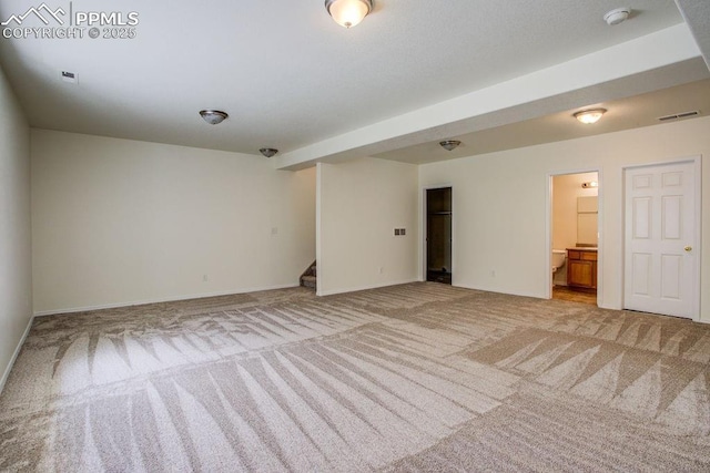 unfurnished room featuring stairs, light colored carpet, visible vents, and baseboards