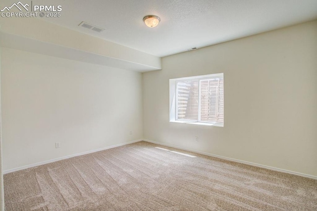 unfurnished room featuring visible vents, baseboards, a textured ceiling, and carpet flooring