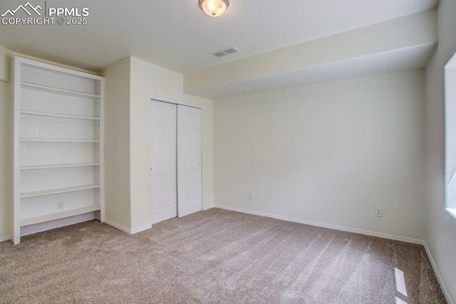 unfurnished bedroom featuring visible vents, baseboards, carpet, and a closet