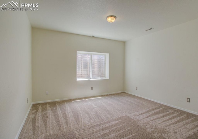 empty room with baseboards, carpet floors, and visible vents