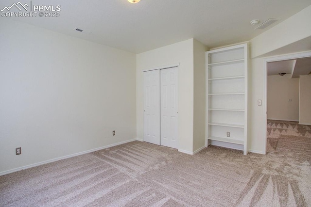 unfurnished bedroom featuring a closet, baseboards, visible vents, and carpet flooring