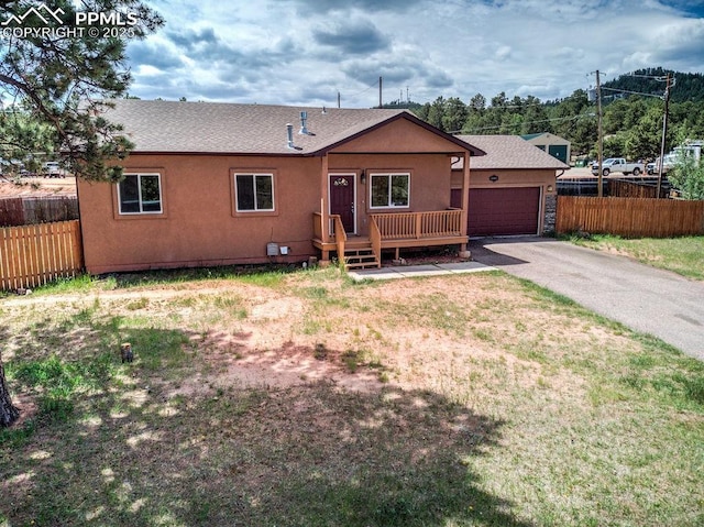 ranch-style home with stucco siding, aphalt driveway, an attached garage, and fence