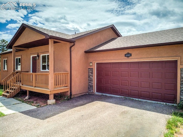 view of front of house featuring aphalt driveway, stucco siding, and a shingled roof