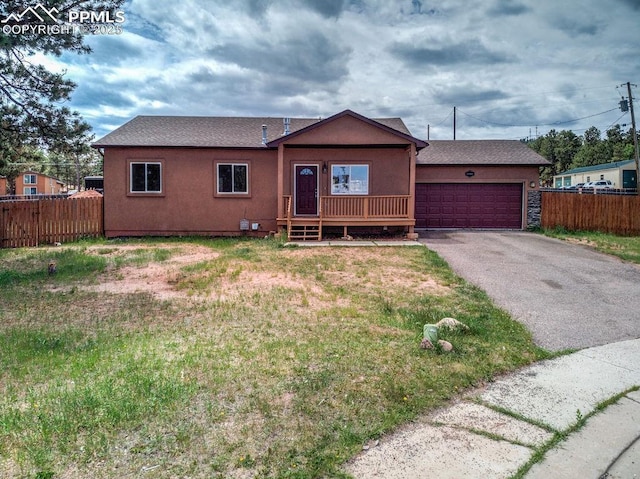 single story home featuring stucco siding, an attached garage, a front yard, and fence