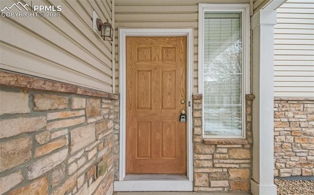 entrance to property with brick siding and stone siding