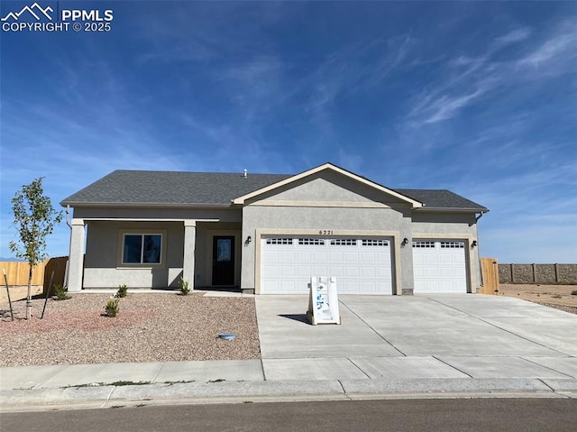 ranch-style house featuring stucco siding, an attached garage, and fence