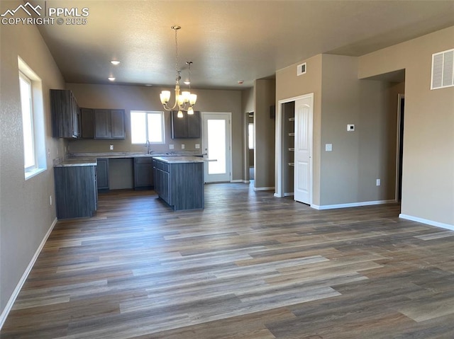 kitchen featuring a sink, visible vents, open floor plan, and light countertops