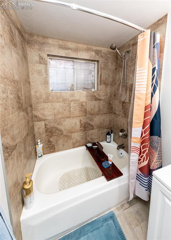 full bath featuring vanity and shower / bath combination with curtain