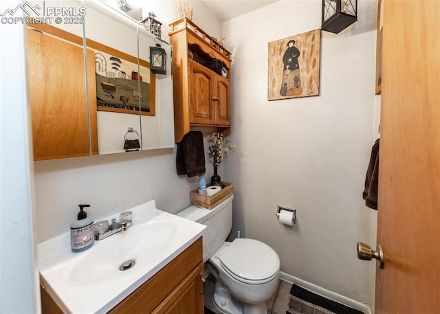 bathroom with vanity, toilet, and baseboards