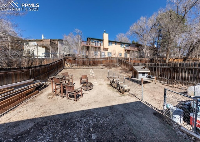 view of yard with an outdoor fire pit, a fenced backyard, and an outdoor structure