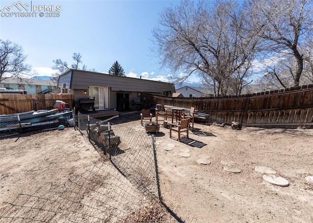 rear view of house with a fire pit, a fenced backyard, and a patio area