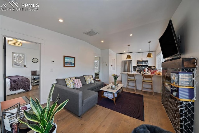 living area with recessed lighting, visible vents, and light wood-type flooring