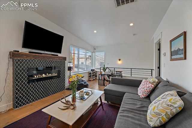 living area featuring recessed lighting, wood finished floors, visible vents, and a tile fireplace