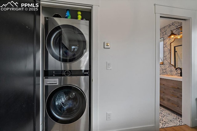 laundry area featuring stacked washer / drying machine and laundry area