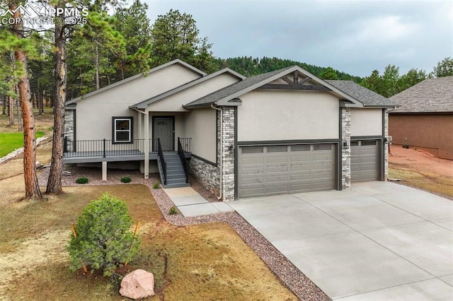 1309 Stone Ridge Dr, Woodland Park, CO 80863 - single story home with stone siding, stucco siding, an attached garage, and driveway