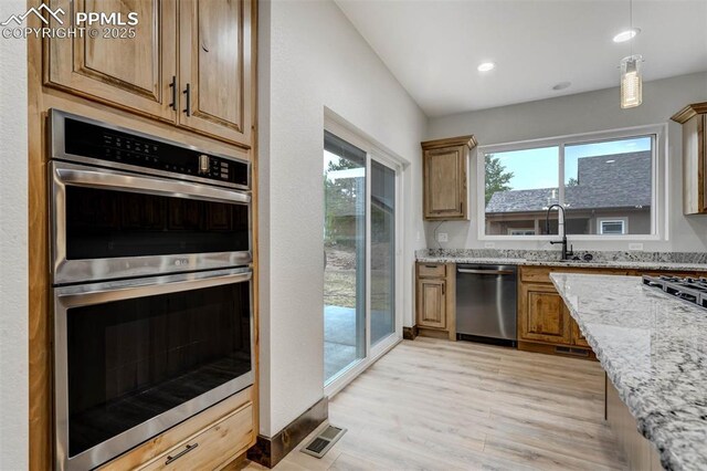 1309 Stone Ridge Dr, Woodland Park, CO 80863 - kitchen featuring visible vents, light stone countertops, light wood-type flooring, stainless steel appliances, and a sink