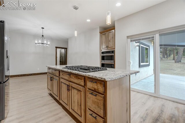1309 Stone Ridge Dr, Woodland Park, CO 80863 - kitchen with light wood finished floors, baseboards, light stone counters, recessed lighting, and stainless steel appliances