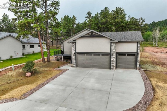 1309 Stone Ridge Dr, Woodland Park, CO 80863 - single story home with an attached garage, stone siding, driveway, and stucco siding