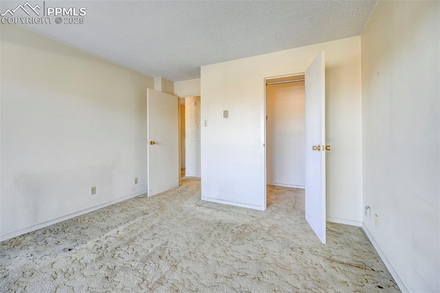 unfurnished bedroom with baseboards, a textured ceiling, and carpet flooring