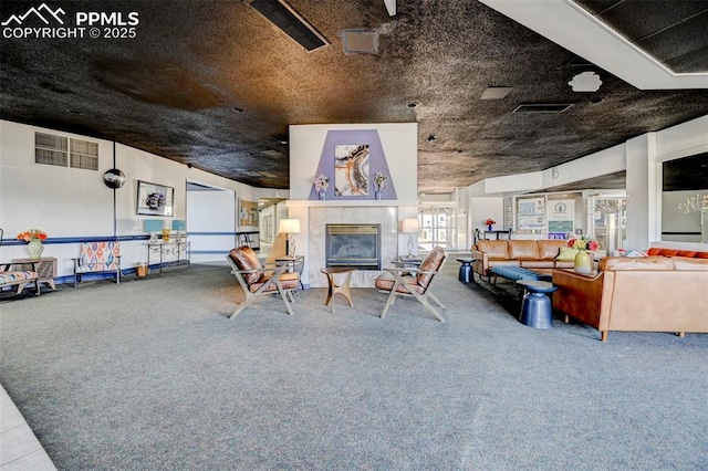 living room with visible vents, a tile fireplace, and carpet floors