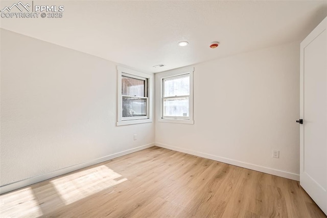 spare room with visible vents, baseboards, and light wood-type flooring