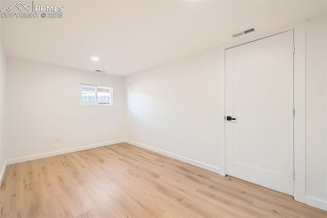 spare room with baseboards, visible vents, and light wood-type flooring