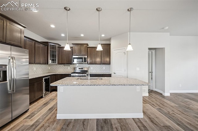 kitchen with decorative backsplash, dark brown cabinetry, appliances with stainless steel finishes, and a sink