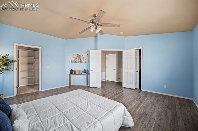 bedroom with a closet, baseboards, wood finished floors, and vaulted ceiling