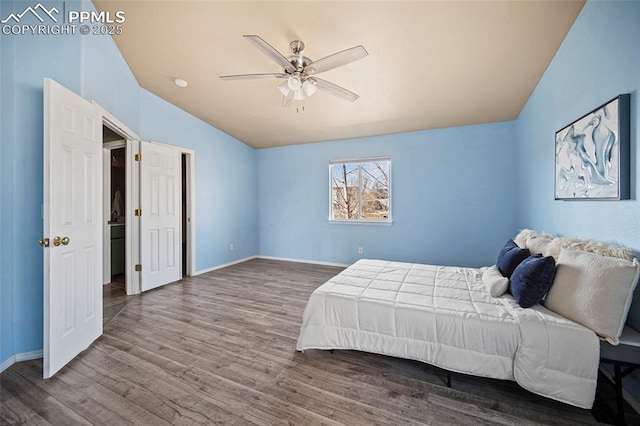 bedroom with ceiling fan, baseboards, lofted ceiling, and wood finished floors