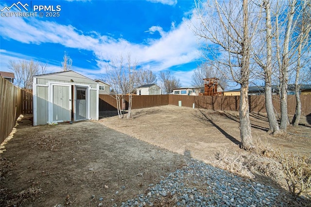 view of yard featuring an outbuilding, a storage shed, and a fenced backyard