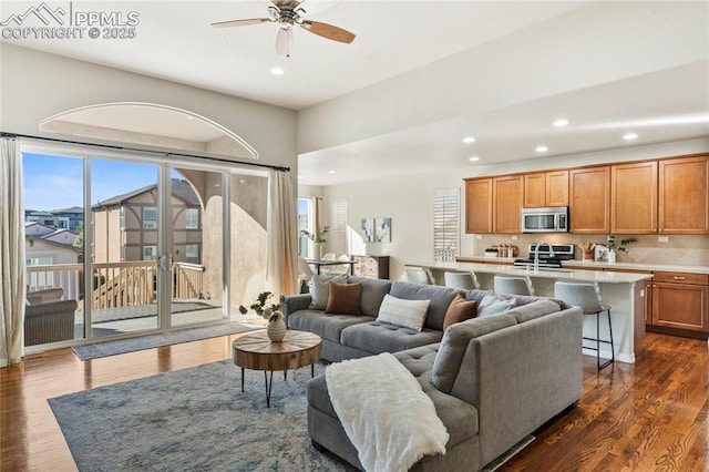 living room featuring recessed lighting, a ceiling fan, and dark wood-style flooring