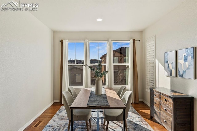 dining space with visible vents, baseboards, and dark wood-style flooring