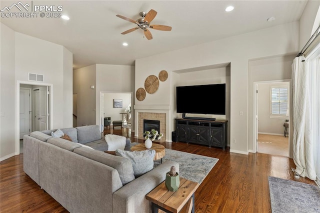 living area with dark wood-style floors, visible vents, recessed lighting, and baseboards