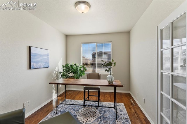 office space featuring visible vents, baseboards, and wood finished floors