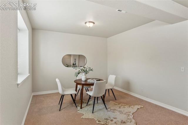 carpeted dining area with baseboards and visible vents