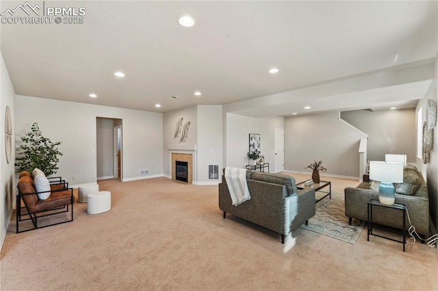 living room with visible vents, baseboards, a fireplace, recessed lighting, and light colored carpet