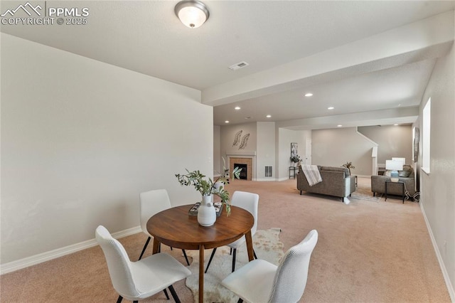 dining area with visible vents, baseboards, a tiled fireplace, light colored carpet, and recessed lighting