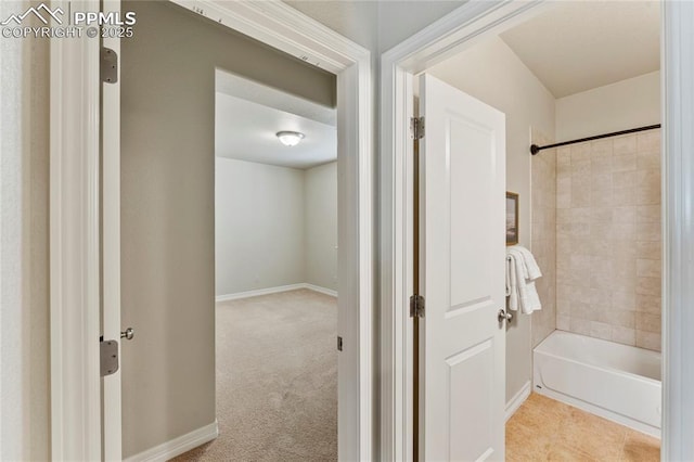 bathroom with shower / bath combination and baseboards