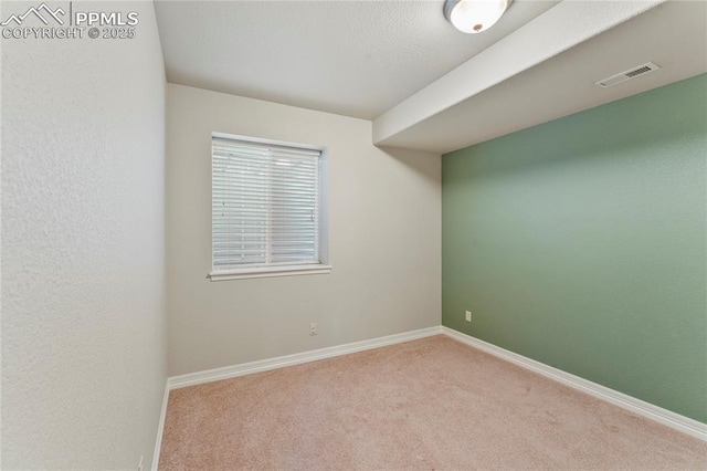 carpeted empty room featuring visible vents and baseboards